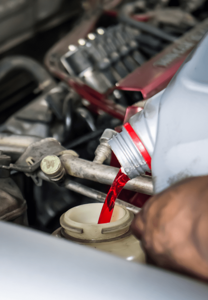 Service technician adding coolant